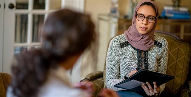psychologist wearing a head scarf talking to a client