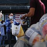 people handing out bags of food