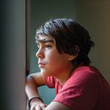 tween boy looking out a window