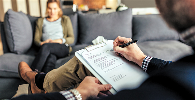 psychologist with clipboard and patient sitting across from him