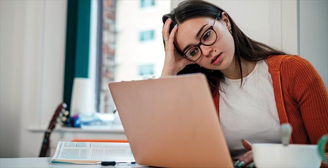 woman at a laptop looking frustrated