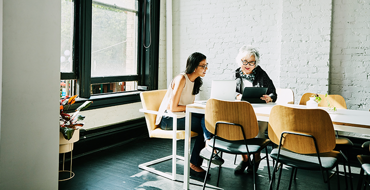 Two women discussing a project in classroom