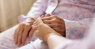person holding an elderly woman’s hand