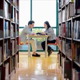 Young man and woman collaborating on an educational project in a peaceful university library
