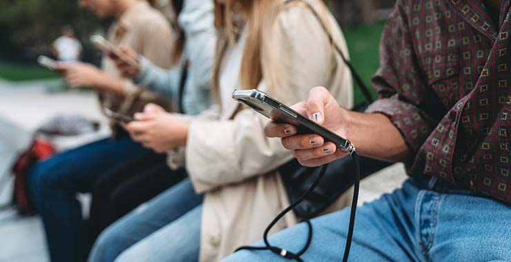 group of people all looking down at their smartphones