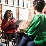 woman in wheelchair talking to colleagues