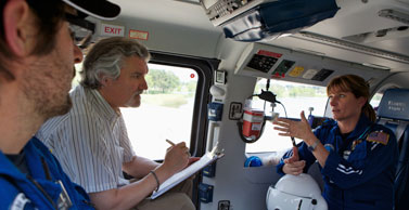 Dr. Salas sits in a helicopter with pilots.