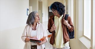 two faculty members walking and chatting