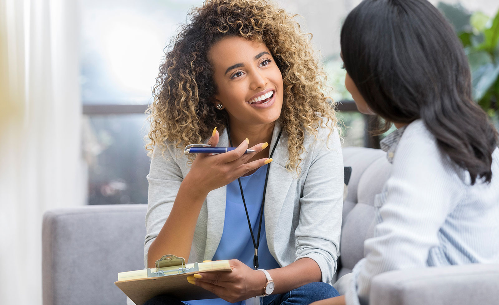 Young female therapist speaks with patient.