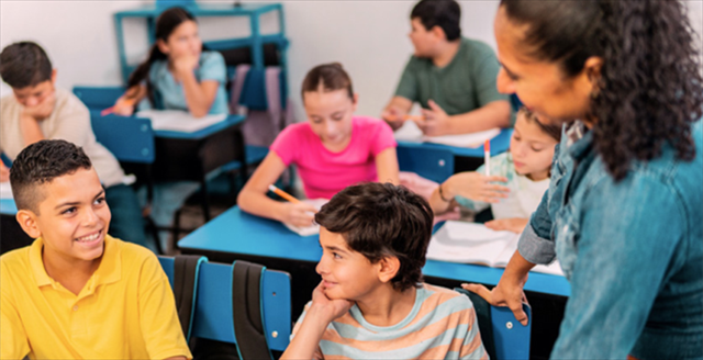 teacher talking with students in classroom