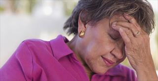 Latina woman rubbing her forehead