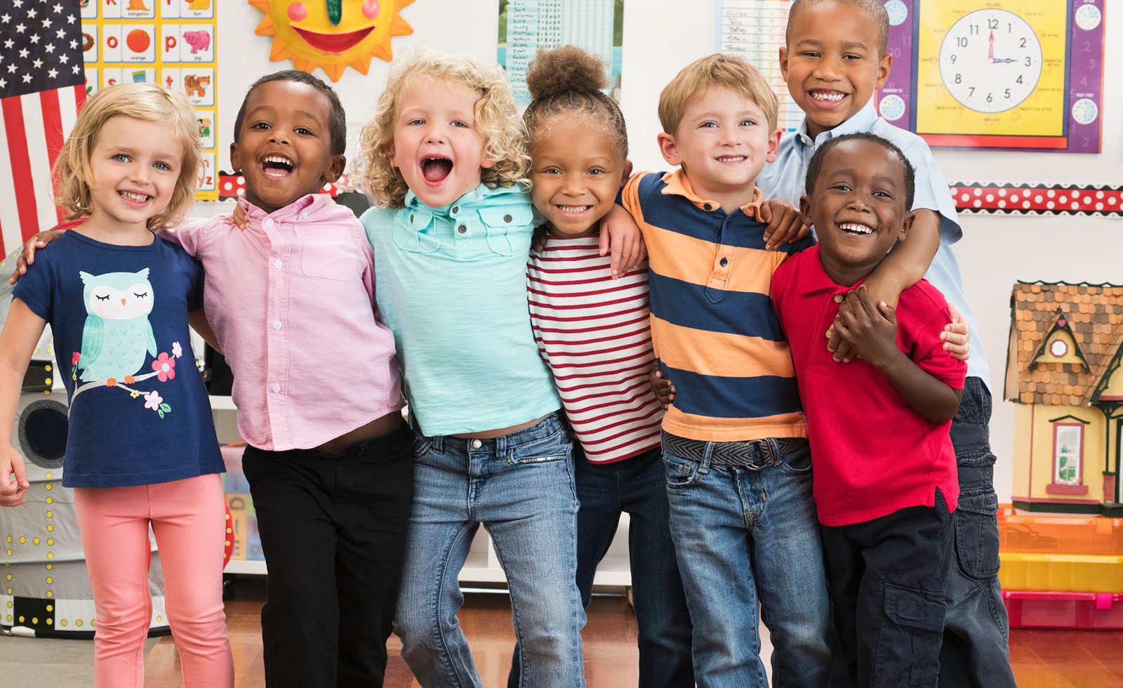 Diverse group of preschool children smiling at the camera.