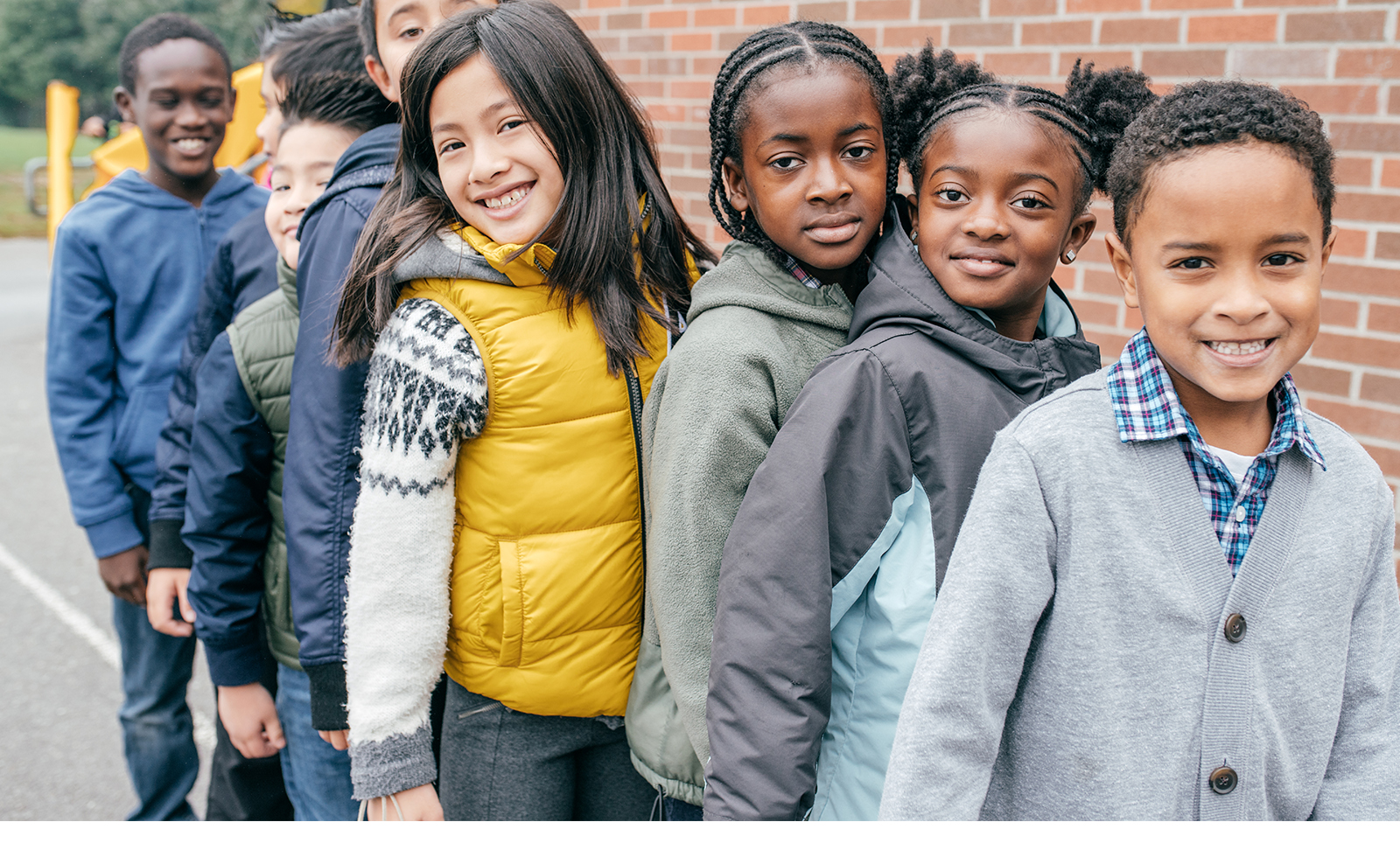 School children stand in a line outside of the school