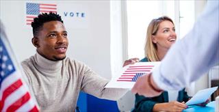 poll worker handing ballot to voter